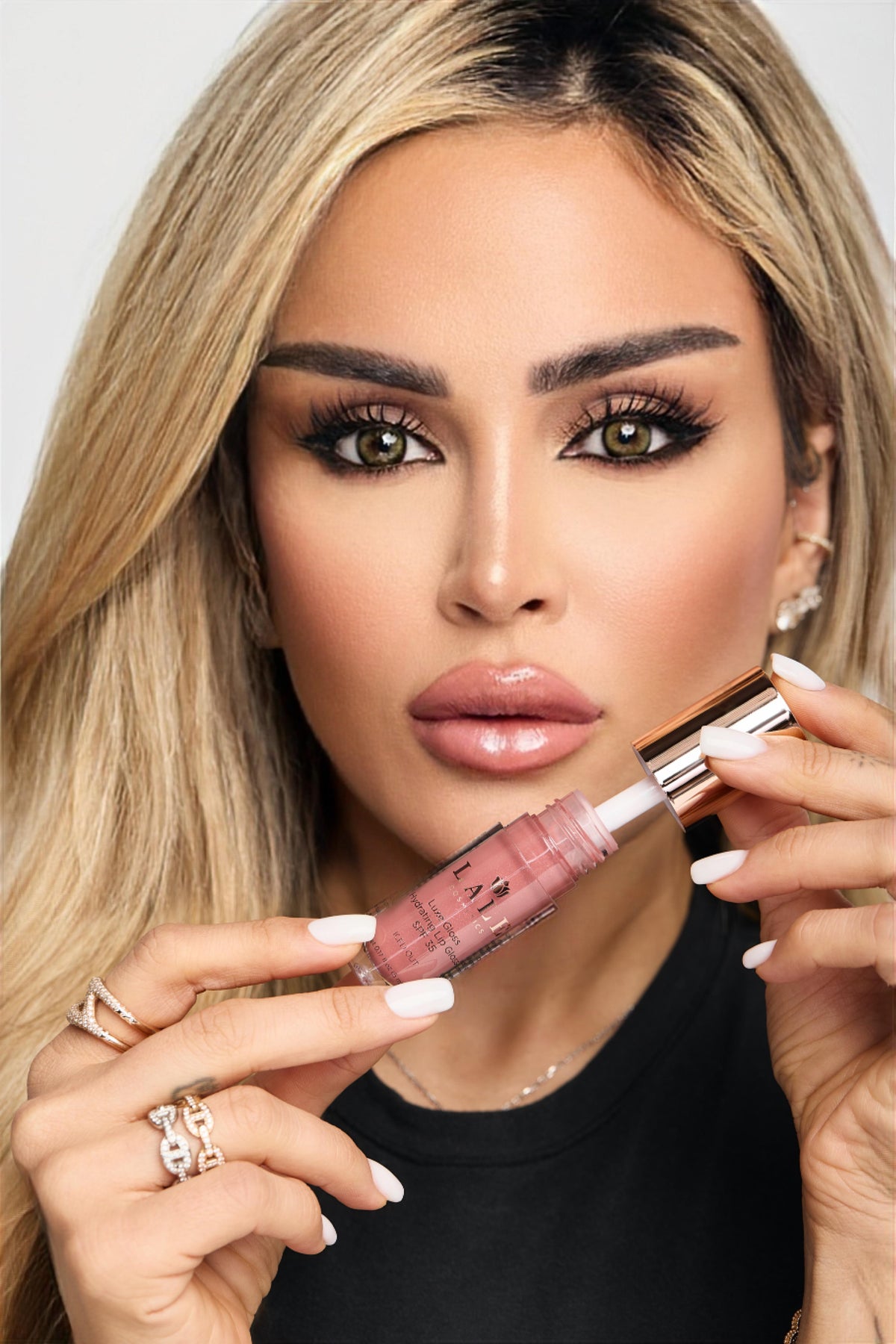 Model applying LALE Luxe Gloss Hydrating Lip Gloss SPF 35
